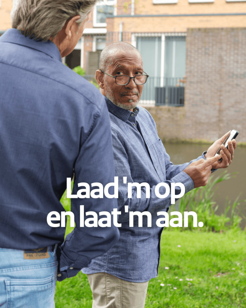 2 mannen, 1 meneer heeft zijn telefoon in zijn hand en kijkt de andere man aan.