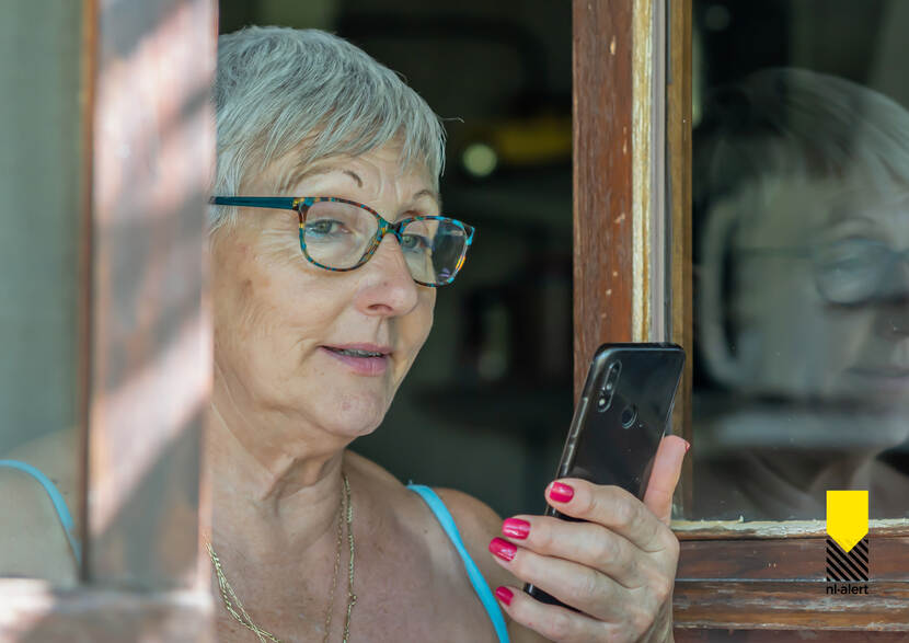 Vrouw met mobiele telefoon in haar hand.