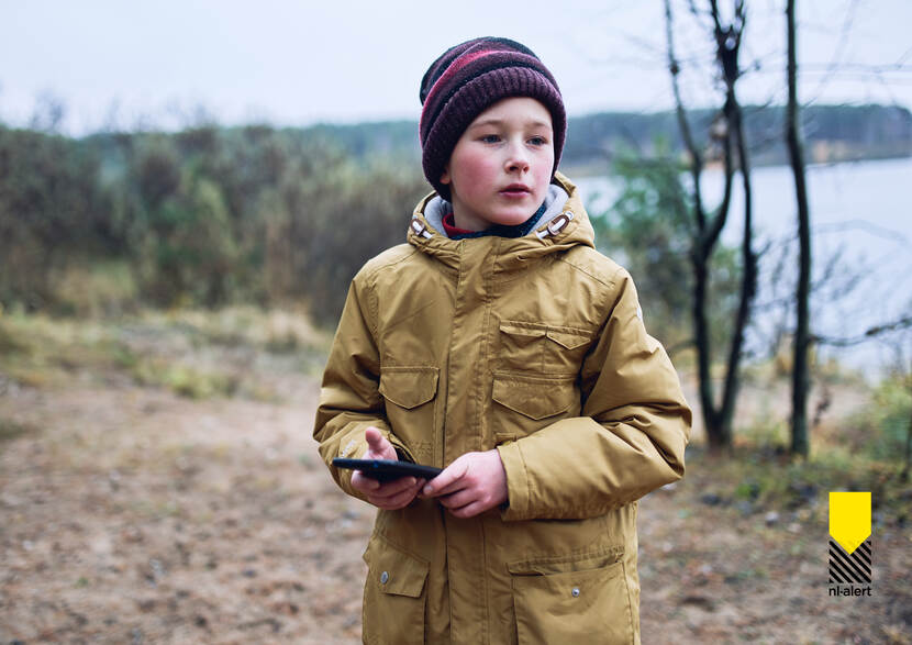 Vrouw kijkt op mobiele telefoon in haar hand.